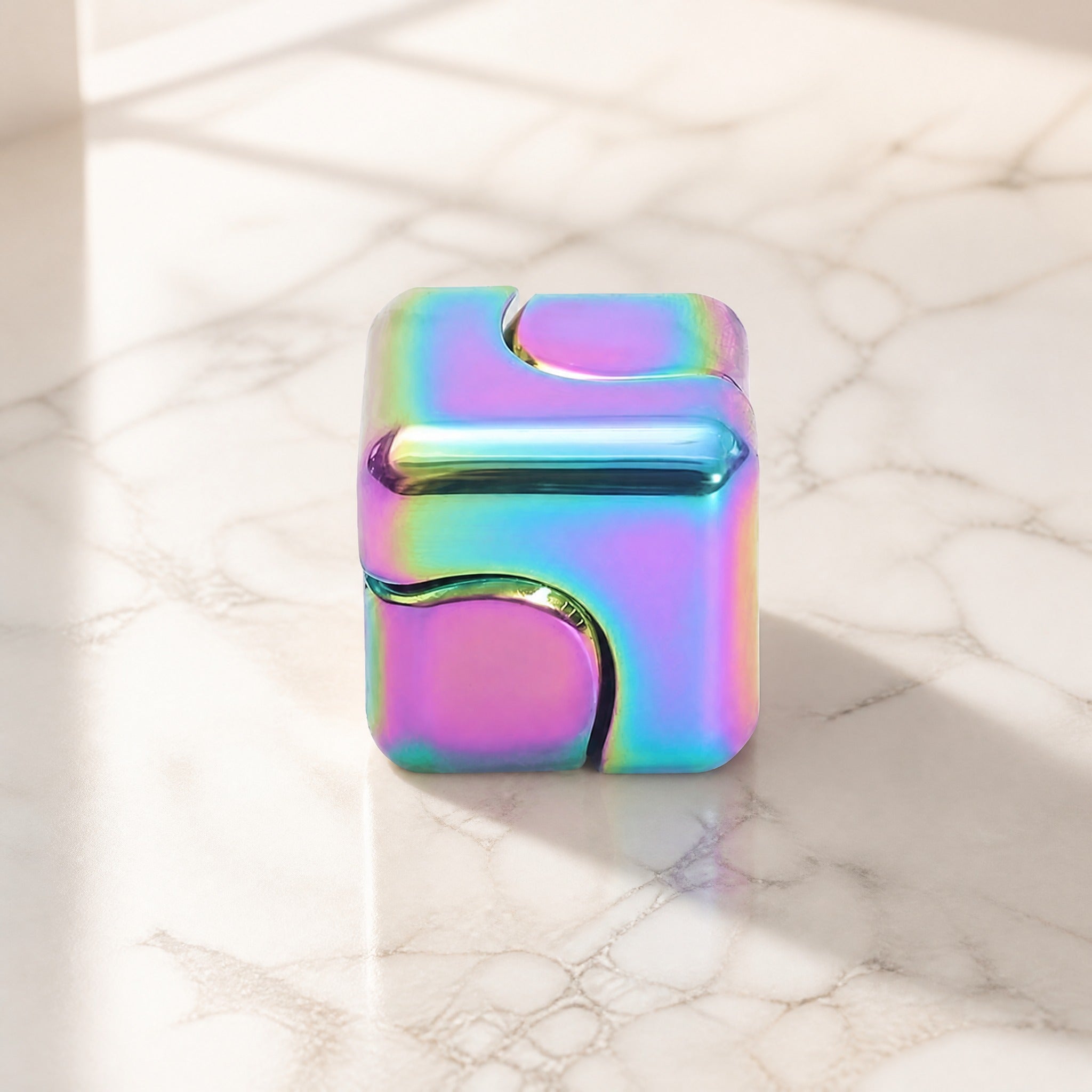 Metal fidget cube interlocking on marble surface