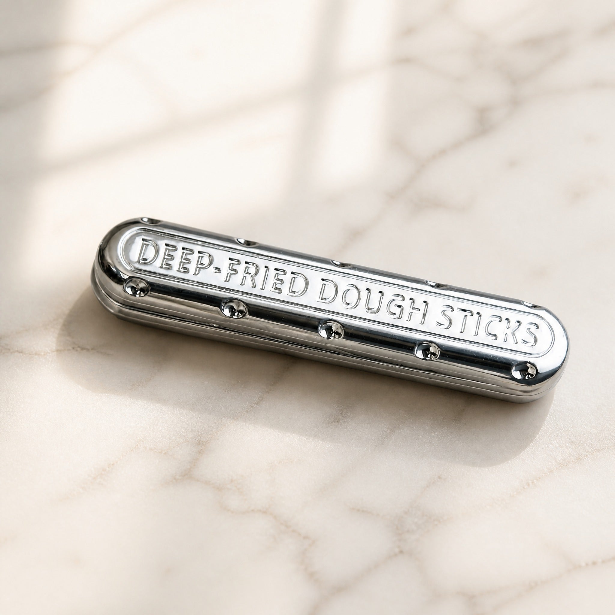 Pill fidget bar metal EDC keychain on marble surface